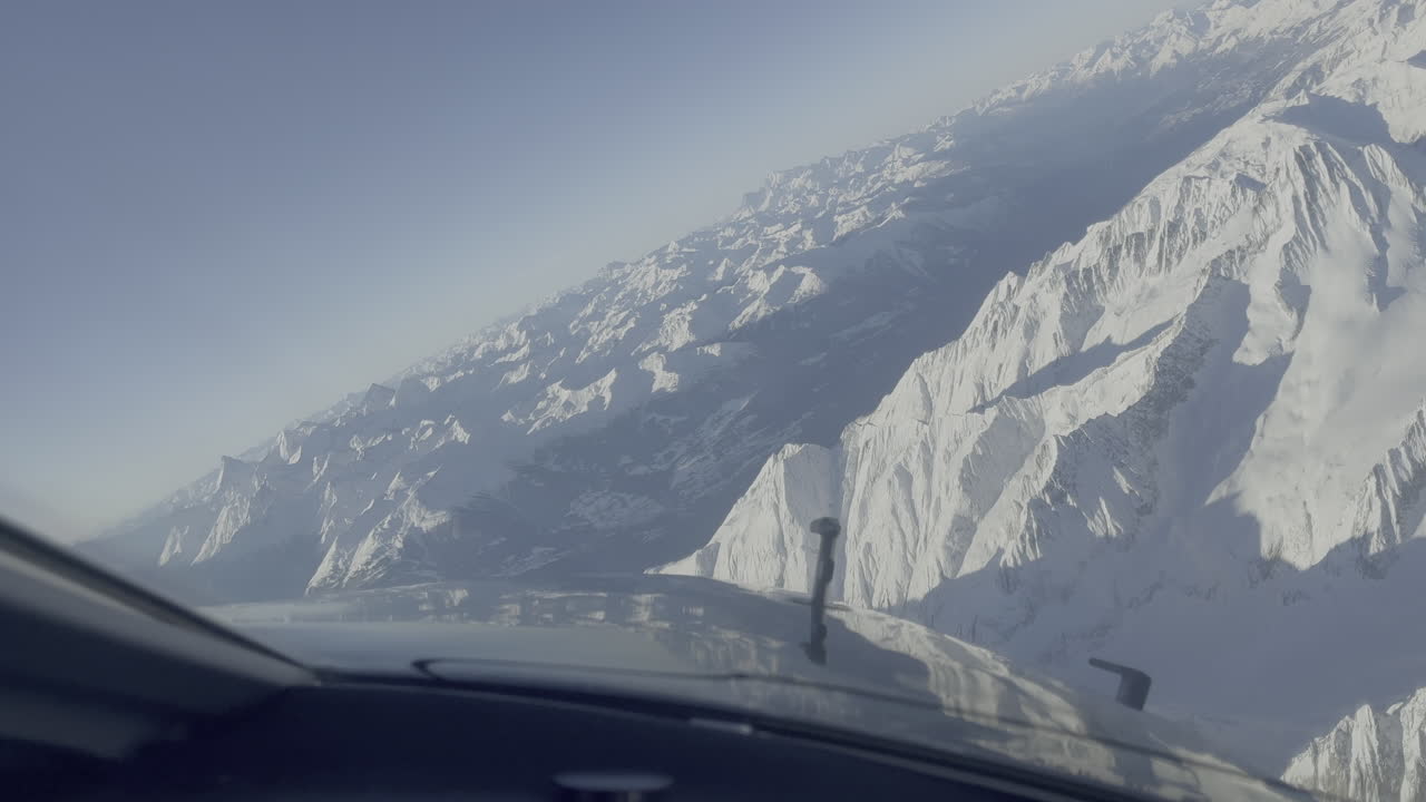 Light passenger aircraft aerial view approaching Sion snow covered Swiss mountains