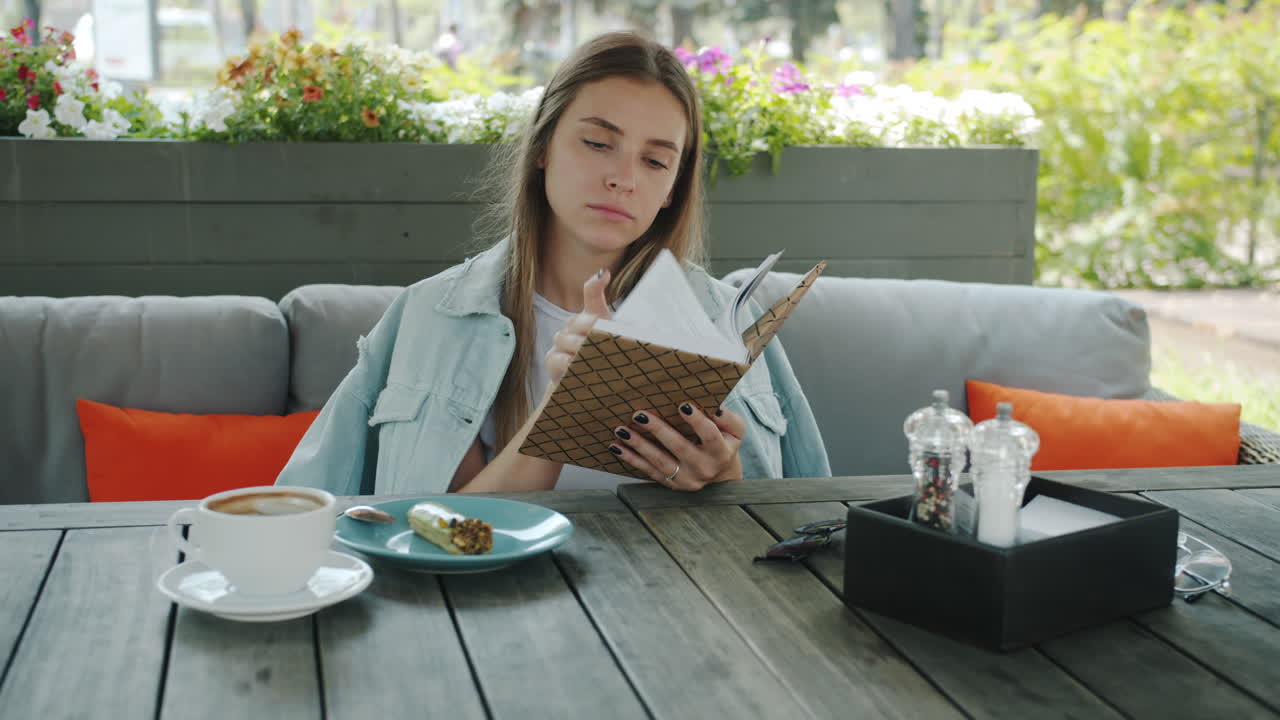 Woman Reading Book in a Cafe