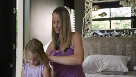 mother brushing the hair on her daughter