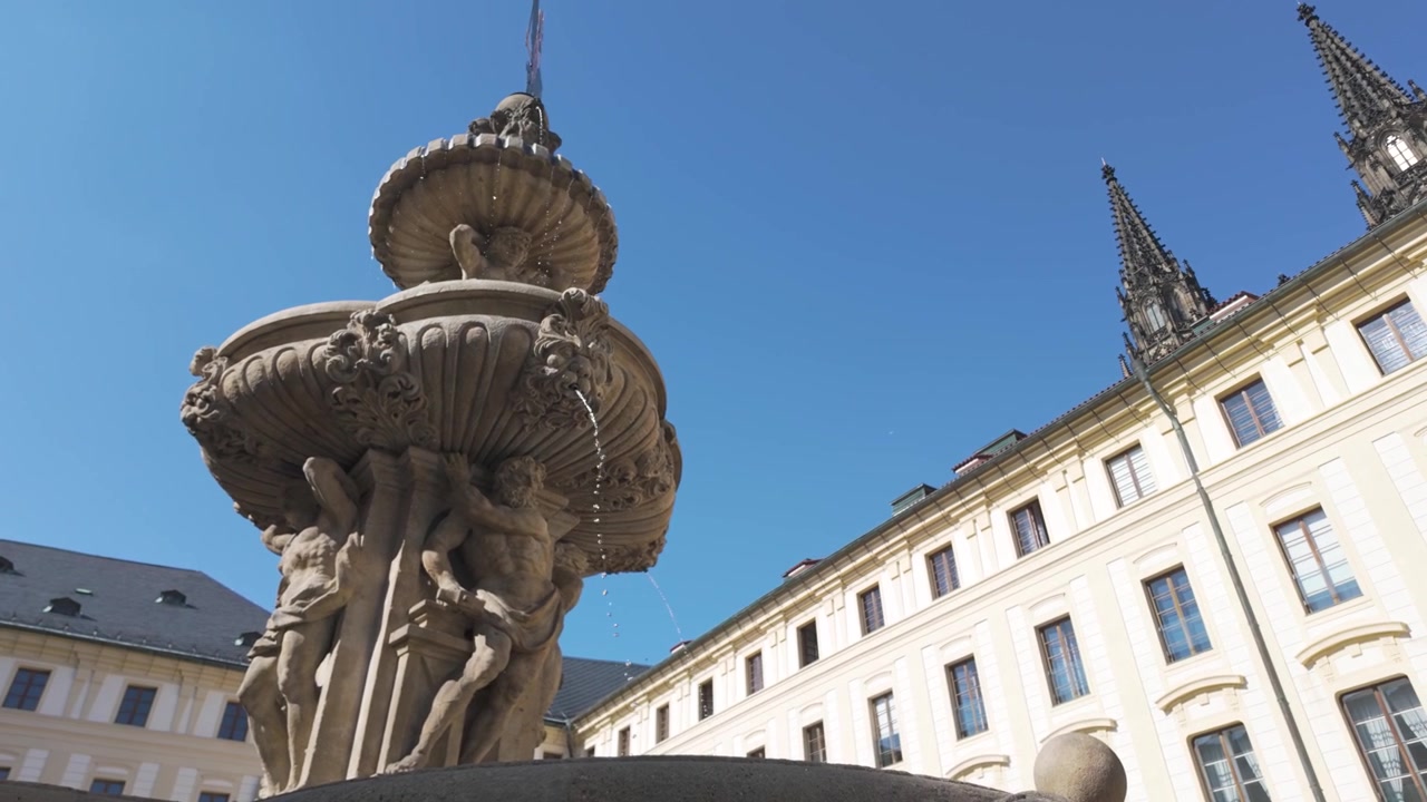Vista ascendente de la fuente del Segundo Patio del Castillo de Praga, destacando la grandiosa arquitectura y el entorno histórico