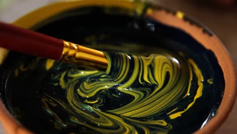 potter mixing paint into bowl