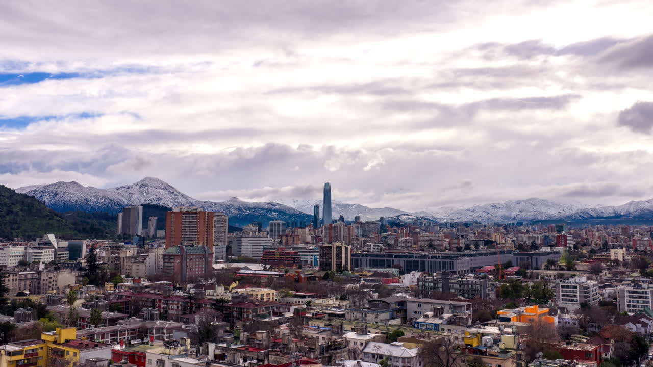 Hyperlapse con zoom dello skyline di Santiago con il Costanera Center e nuvole in rapido movimento sulle Ande