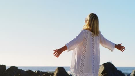 Disabled-woman-standing-with-arms-outstretched-in-the-beach-4k