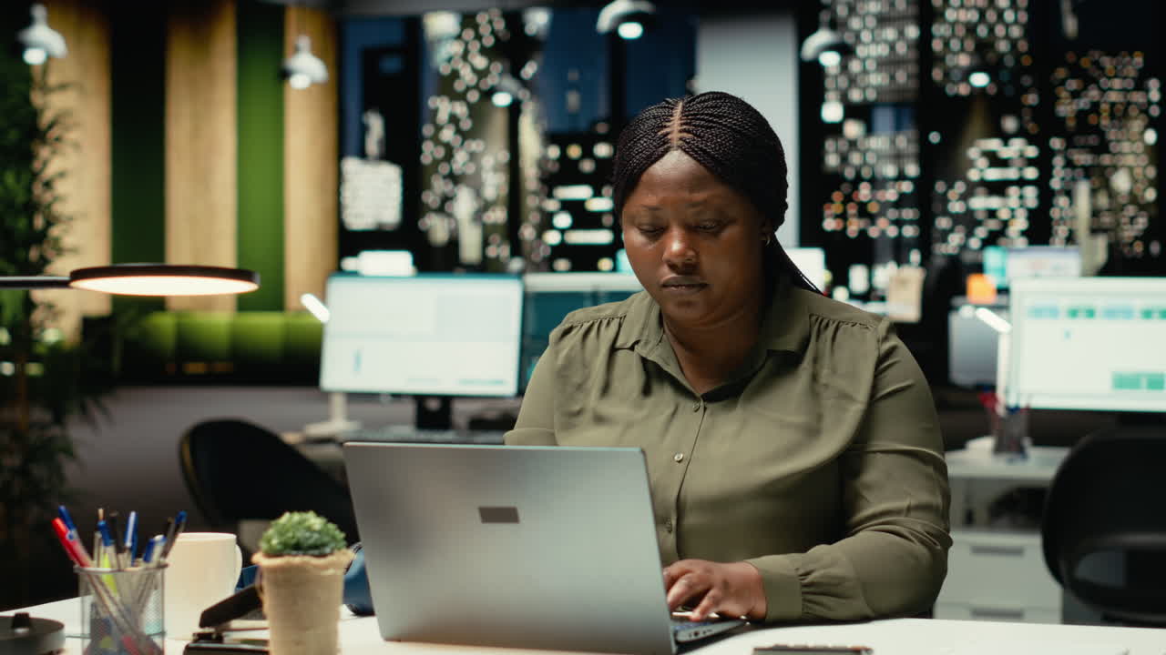 African american person playing with a pen at the office in deep contemplation