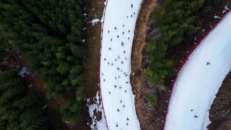 Aerial-ascend-over-Dolni-Morava-skiing-track-slope-with-people-going-downhill