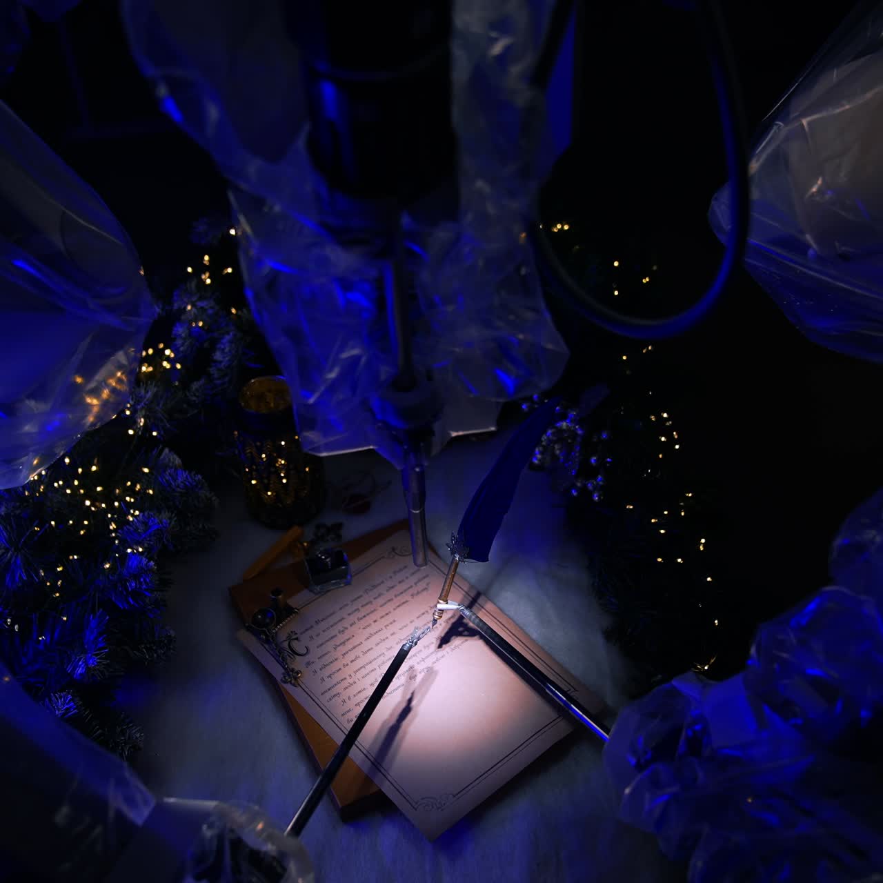 Da Vinci robot writing Christmas letter on the operational table. Thin metal forceps hold a writing pen. Festive decorations around. Top view