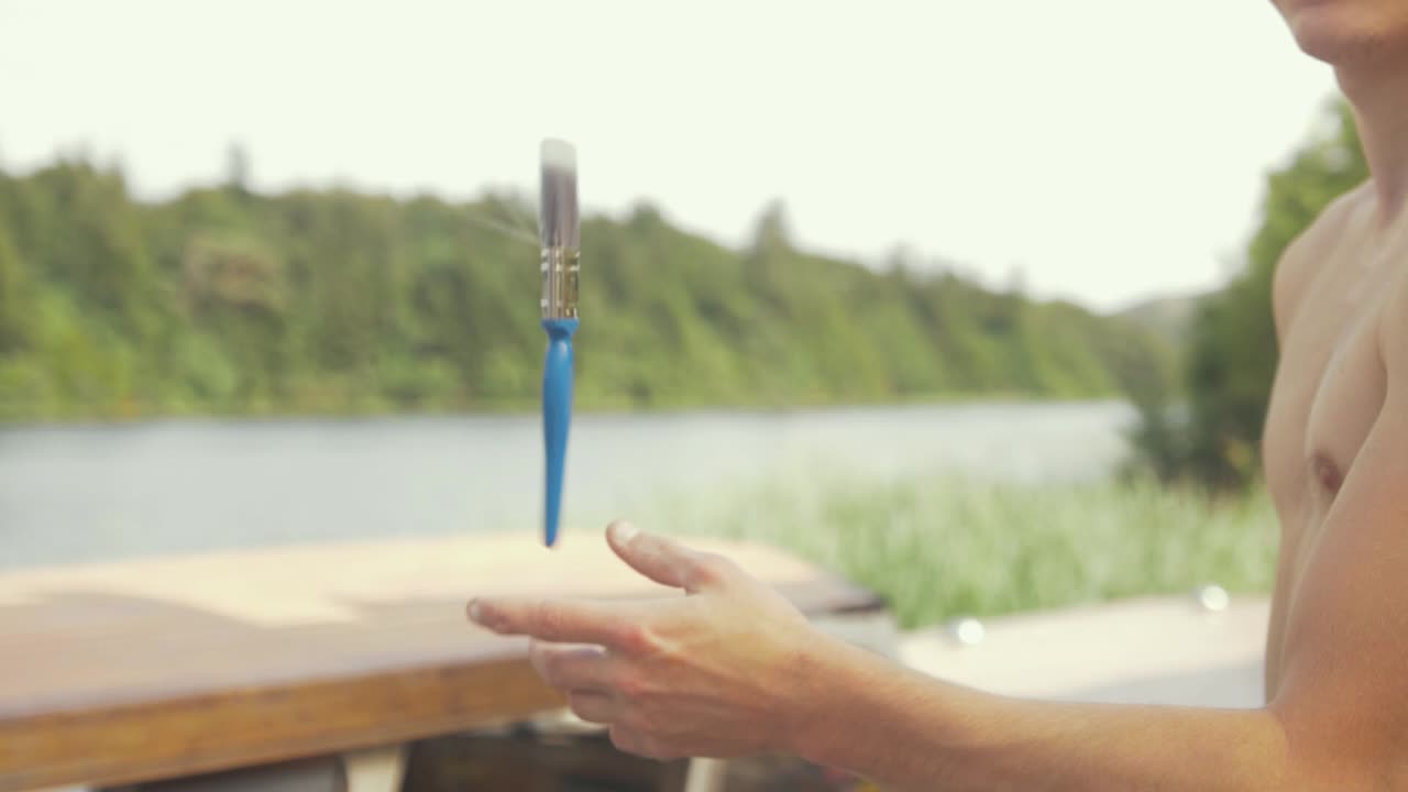 joven en topless lanza pincel al aire libre a cámara lenta, tiro lateral