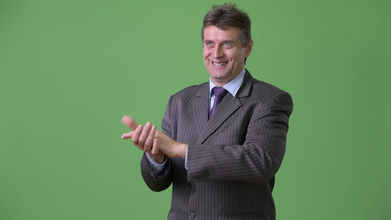 hombre de negocios maduro y guapo contra un fondo verde