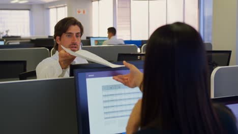 vista frontal de un joven ejecutivo caucásico dando documentos a su colega en una oficina moderna 4k