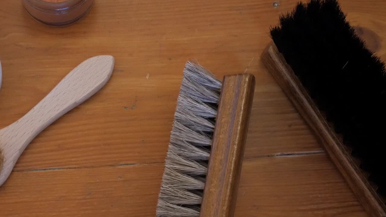 Closeup of shoe polishing brushes on a wooden table; crafting tools