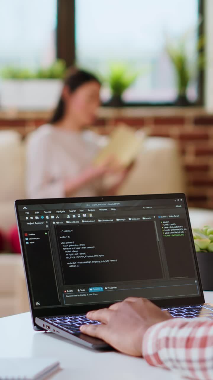 Vertical Video Male programmer developing an app on his laptop and working remotely