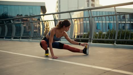 young girl in a sports uniform doing stretching on the road in the morning. fitness class and stretching on the city street in the morning