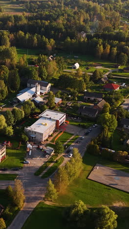vertical aerial view countryside town with autumn forest background of augšlīgatne in latvia.