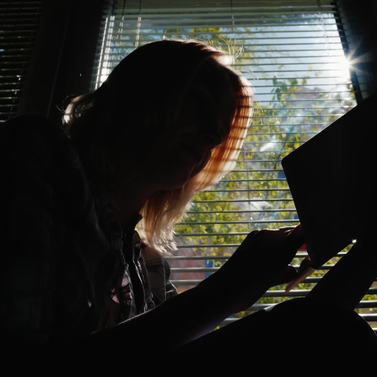 창가에서 책을 읽는 여성의 실루엣