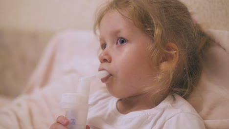 curly girl undergoes procedure with inhaler for cold in bed