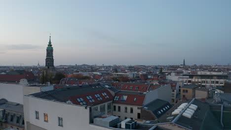 Nach-Vorne-Fliegen-über-Der-Hofanlage-Hackesche-Hofe-Bei-Sophienkirche-Mit-Hohem-Turm.-Luftpanoramablick-Auf-Die-Stadt-In-Der-Abenddämmerung.-Berlin,-Deutschland