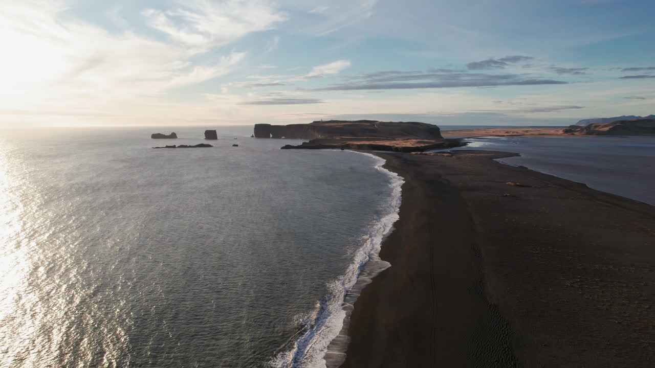 costa de playa de arena negra durante la hermosa puesta de sol de la hora dorada en el sur de islandia