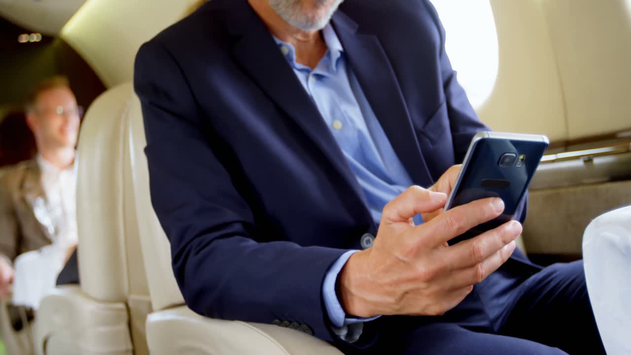 hombre de negocios usando teléfono móvil en un jet privado 4k