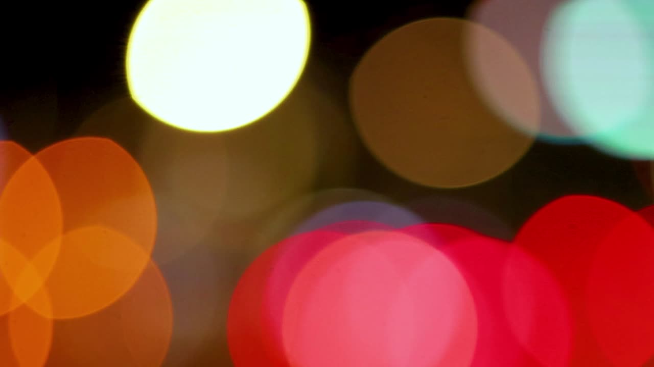 Una visualizzazione con messa a fuoco morbida di cerchi bokeh colorati rossi, arancioni e bianchi che si spostanoFluidamente
