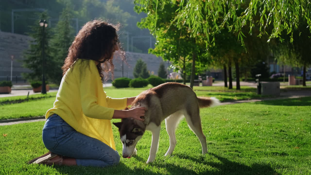 mujer y perro husky en un parque