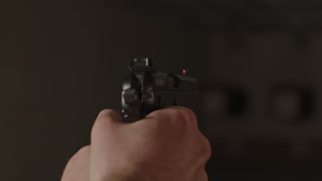 close up of pistol being aimed on shooting range