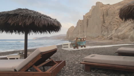 Tracking-shot-of-a-beach-resort-at-the-black-beach-of-Santorini