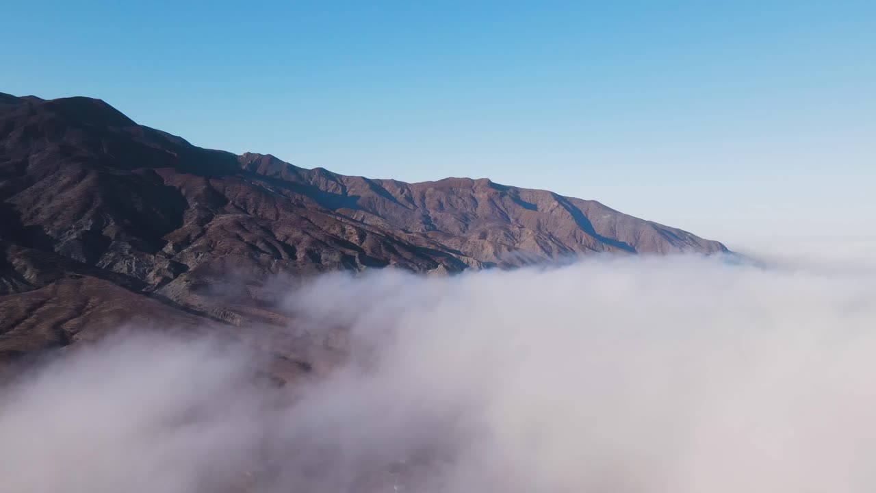 Mountains shrouded in soft mist near Cedros Island, atmospheric sunrise scene from a high vantage point