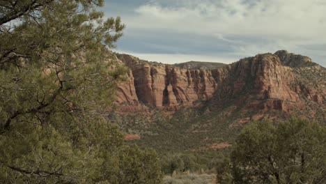 Rocas-Rojas-Y-Colinas-En-Sedona,-Arizona,-Con-Un-Automóvil-Pasando-Con-Una-Filmación-De-Video-Estable.