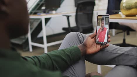 African-american-businessman-using-smartphone-for-video-call-with-business-colleague