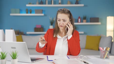 Una-Trabajadora-De-Oficina-En-Casa-Habla-Por-Teléfono-Con-Calificaciones-Femeninas.