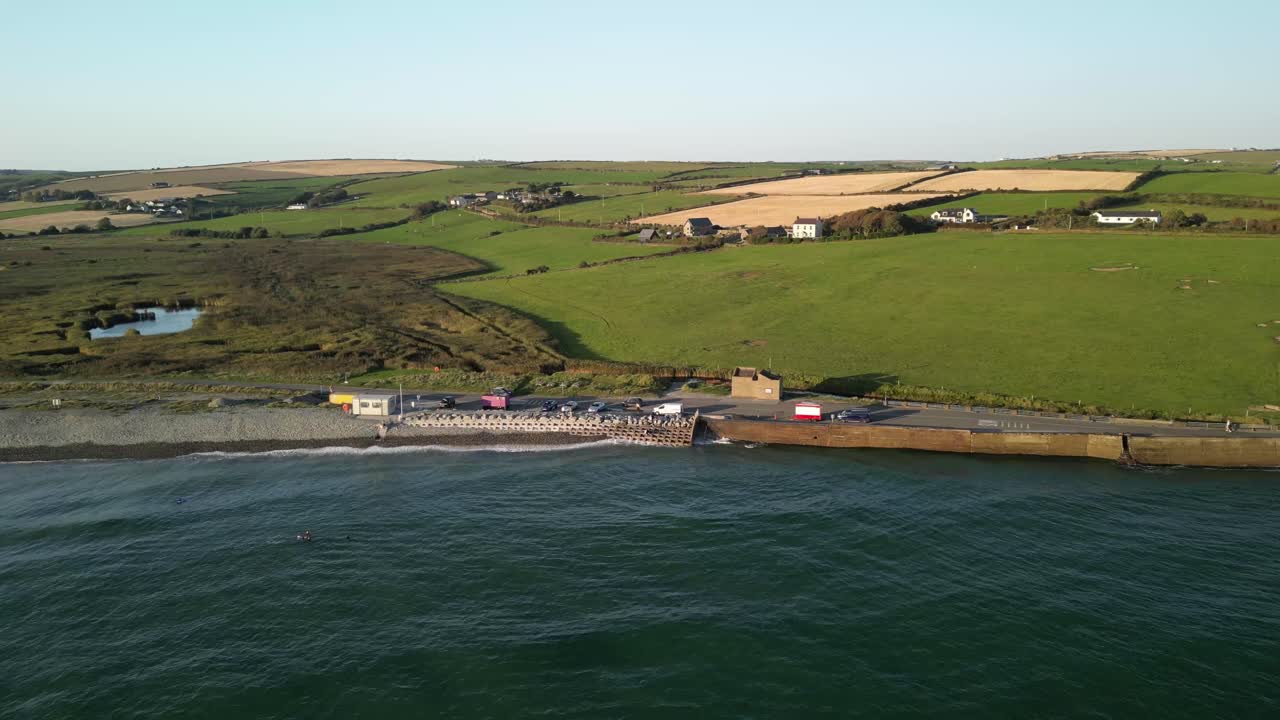 Rural Ireland, Garretstown beach and coastal farms from above. Aerial County Cork. Waves and holiday camper vans.