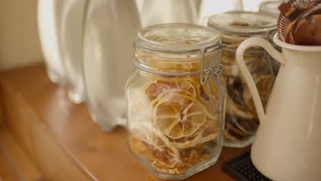 jar of dried citrus slices and bar tools on a wooden shelf, adding a rustic touch to a bar setup