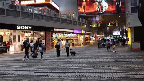 pedestrians walking through a brightly lit plaza