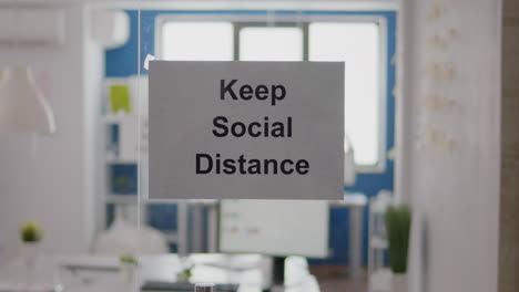 Business-glass-interior-office-with-keep-social-distance-sign