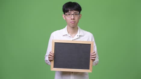 young asian businessman holding blackboard