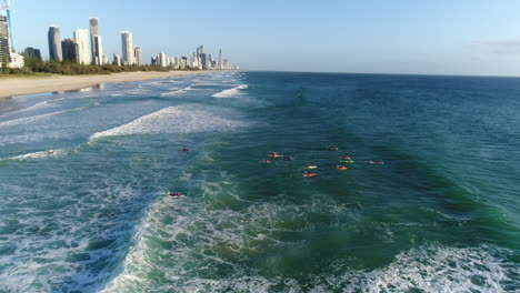 Luftaufnahme-Einer-Gruppe-Von-Zangen,-Die-Während-Einer-Morgendlichen-Trainingseinheit-Am-Mermaid-Beach-Gold-Coast-Australien-Auf-Brettern-Paddeln