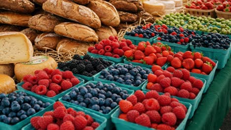 visit a bustling farmers market filled with freshly baked bread and a colorful array of fruits and cheeses. the lively atmosphere draws locals and visitors alike, as vendors display their artisanal products. brightly colored raspberries, blueberries, and blackberries fill baskets, while loaves of cr
