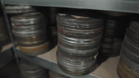archive of shelves with оld round metal boxes with film strip in them.