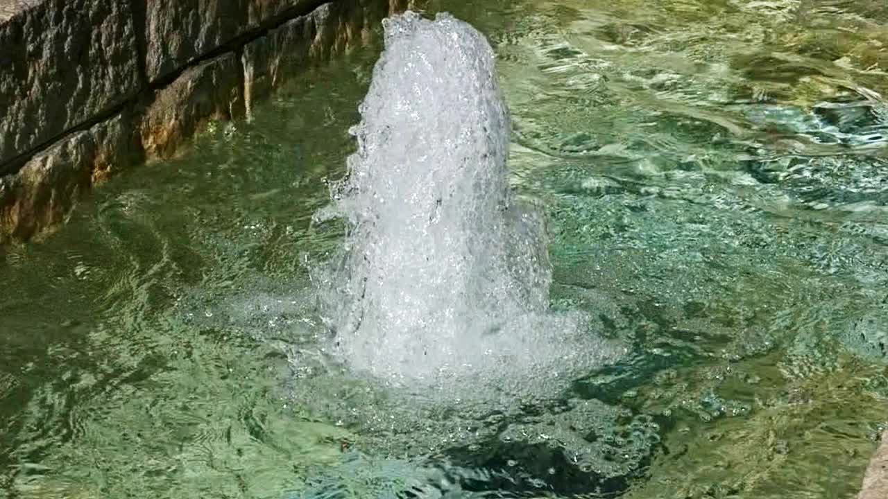 primer plano extremo de una fuente de agua chispeante y reluciente y salpicando en cámara lenta