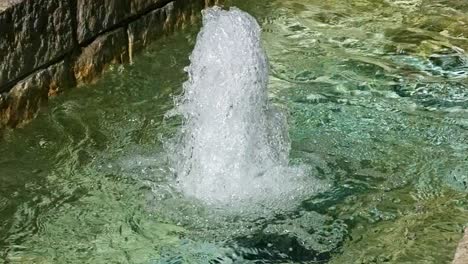 extreme close up of a water fountain sparkling and glistening and splashing slow motion