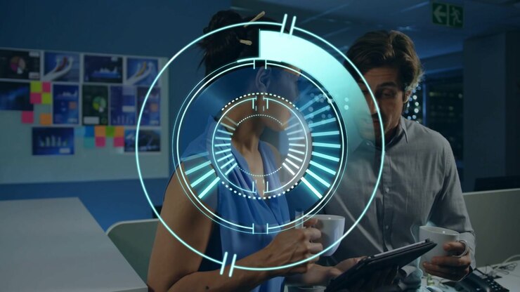 Kvinde scroller på tablet, initierer HUD-ringe, kollega læner sig ind, gennemgår teknisk design sammen.