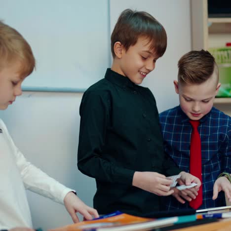 schoolboys playing educative games. elementary school pupils standing in the classroom and talking together. developing study at school.