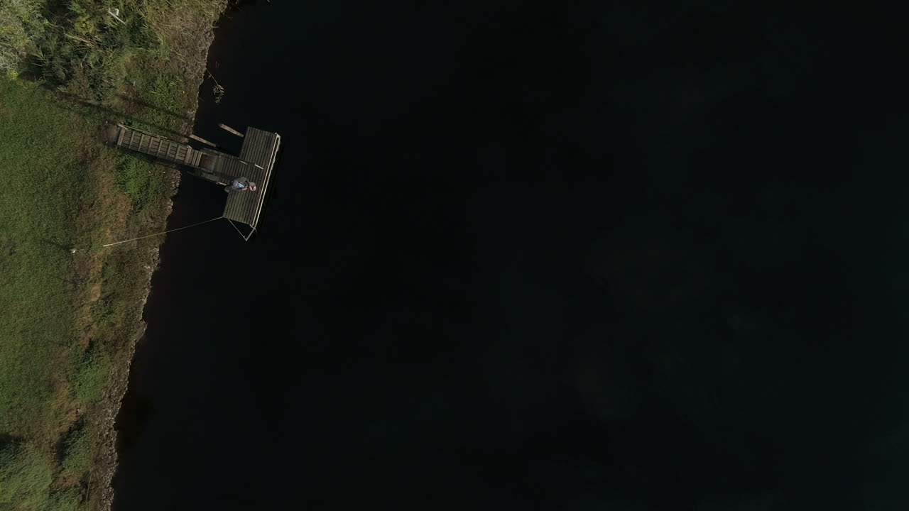 imágenes de drones de un hombre pescando con mosca en un lago