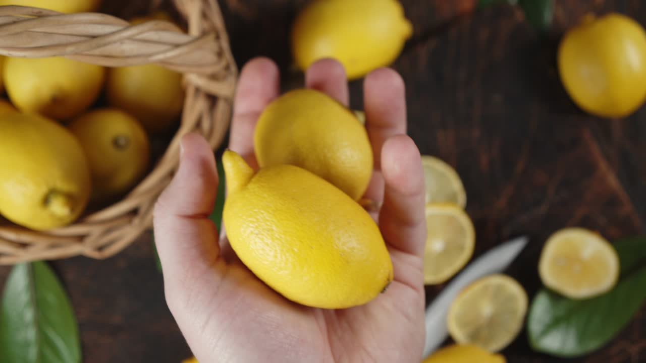 la mano masculina toma limones frescos de la canasta.