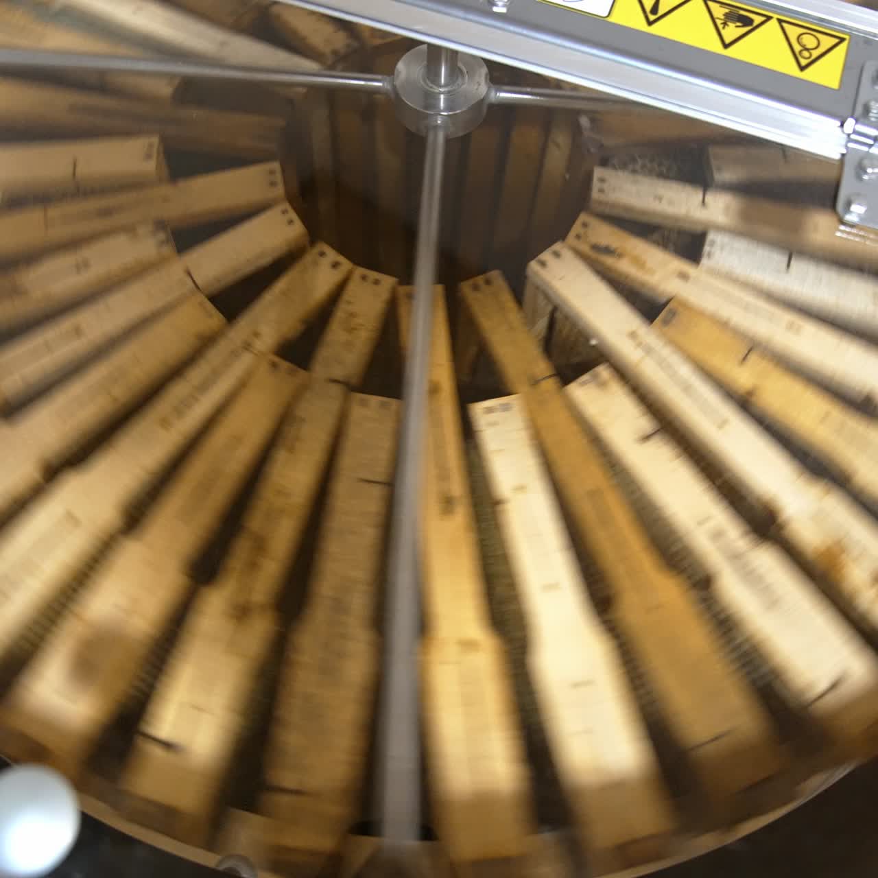 Frames with honeycombs rotating in the centrifuge device for removing honey. Harvest season at bee farm. Close up