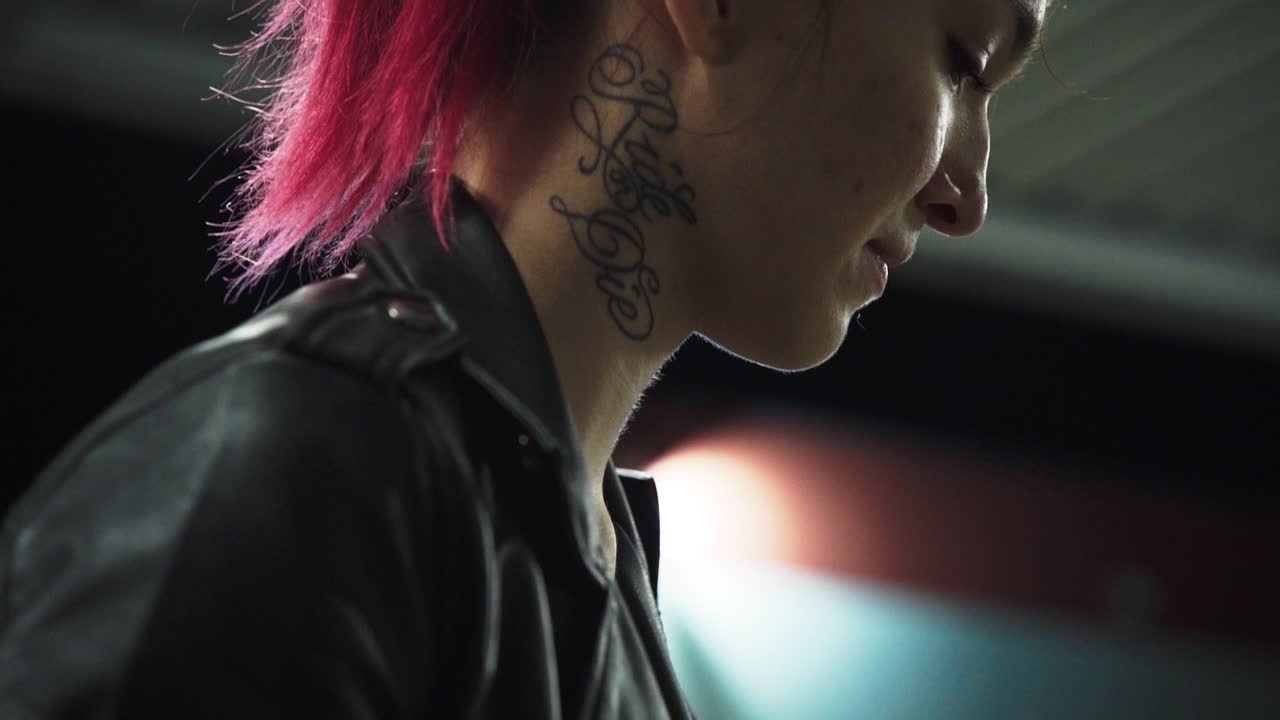 emo mujer punk roja con chaqueta negra con tatuaje en el cuello