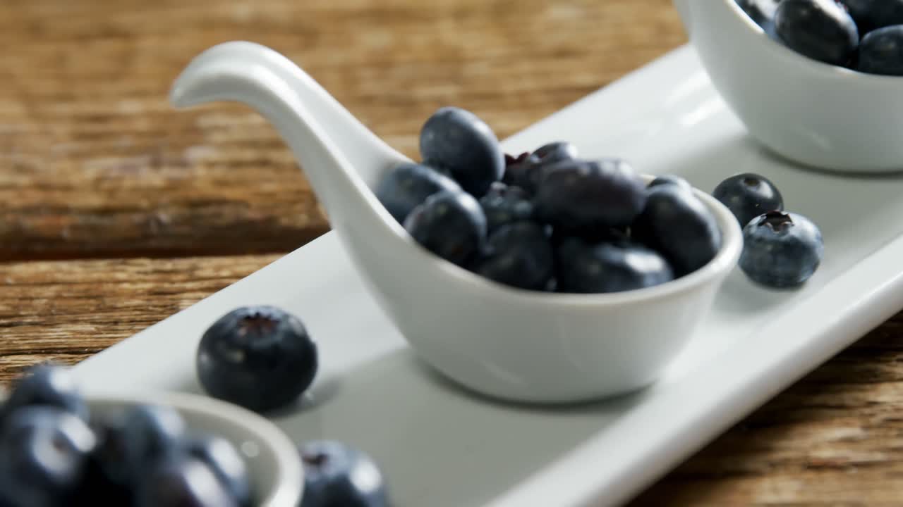 Spoons of blueberries arranged on tray table 4k