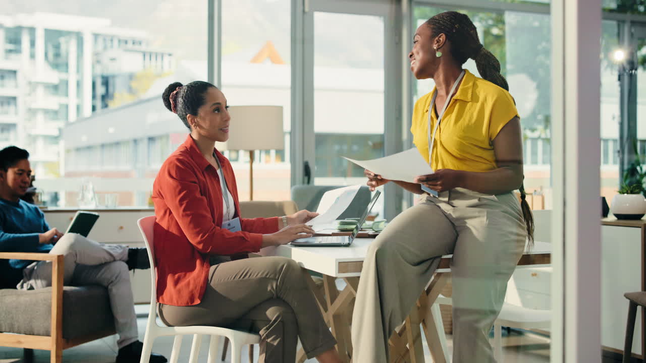 Two Businesswomen Discussing Documents in a Modern Office