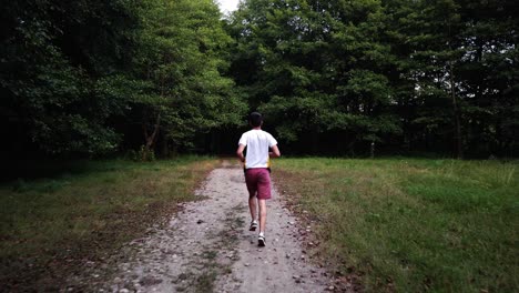 Joven-Varón-Caucásico-Corriendo-En-El-Bosque-Por-Un-Sendero-En-Verano