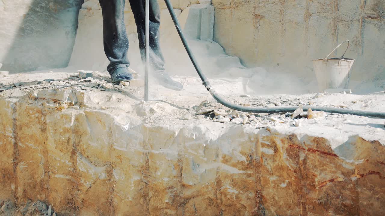 Drilling holes in the stone with a jackhammer. Sandstone mining in the quarry. Close-up